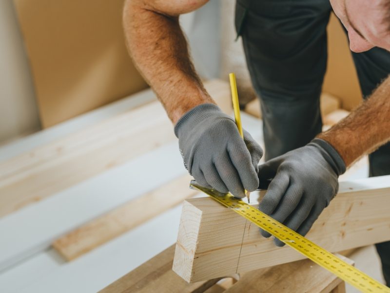 Close,Up,Of,Carpenter,Measuring,Wooden,Board.,Professional,Woodworker,Using