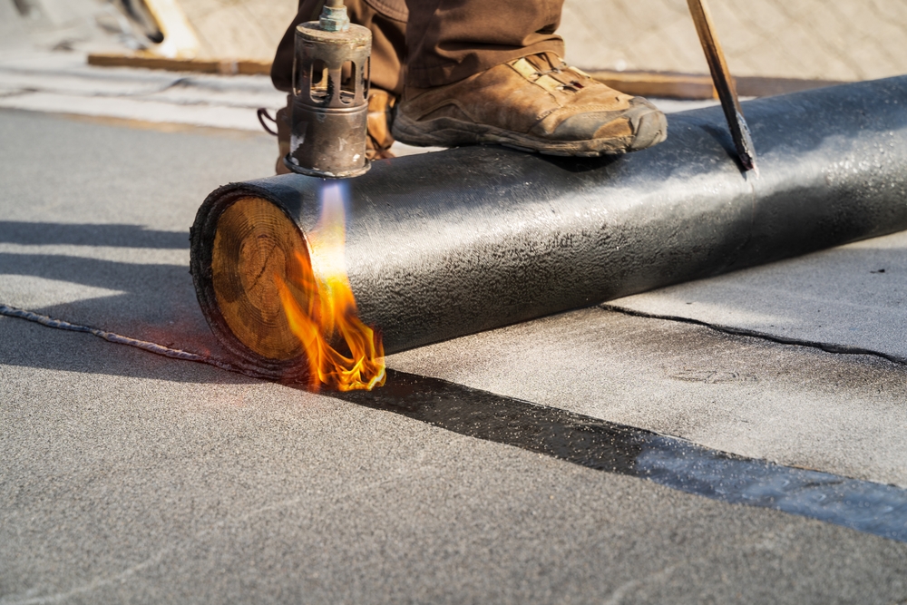 Roofer,Applying,Torch-on,Bitumen,Membrane,For,Waterproofing,Flat,Roofs,In